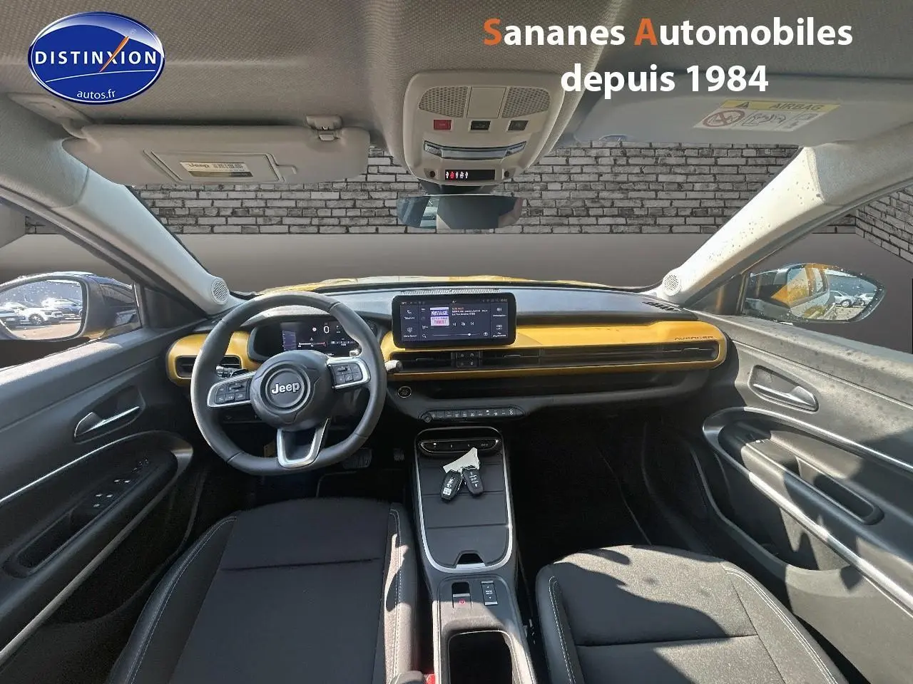 Vue intérieure avant du Jeep Avenger 2025 avec tableau de bord jaune foncé et volant multifonction.
