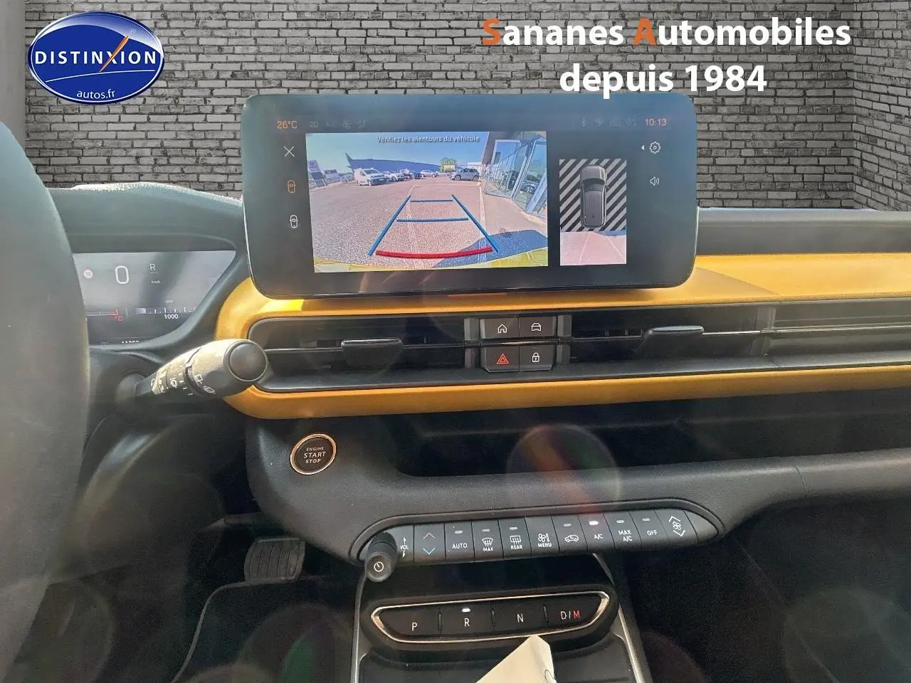 Vue intérieure du tableau de bord du Jeep Avenger jaune foncé, avec écran tactile affichant la caméra de recul.