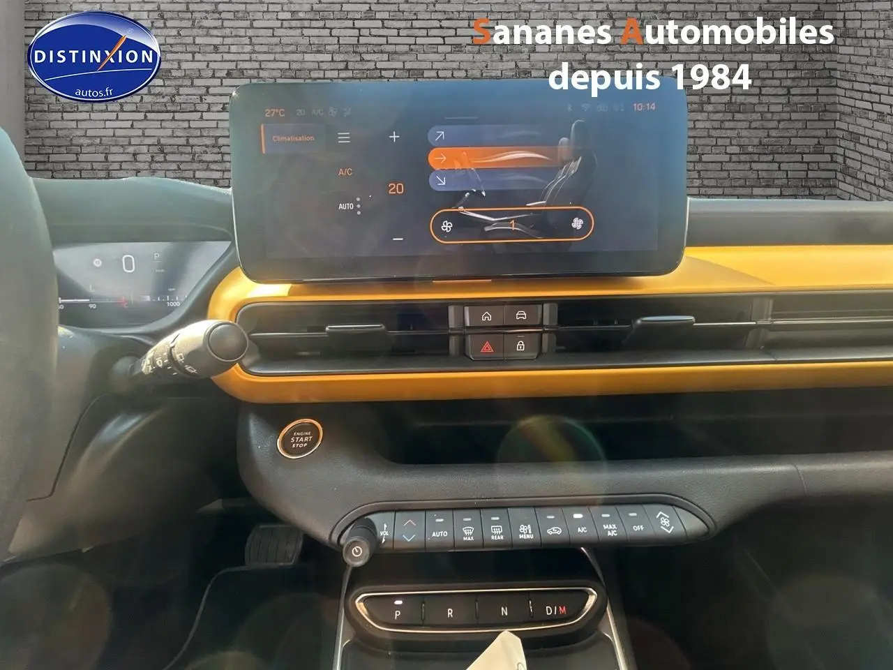 Vue intérieure du tableau de bord jaune foncé du Jeep Avenger 2025 avec écran tactile et commandes climatisation.