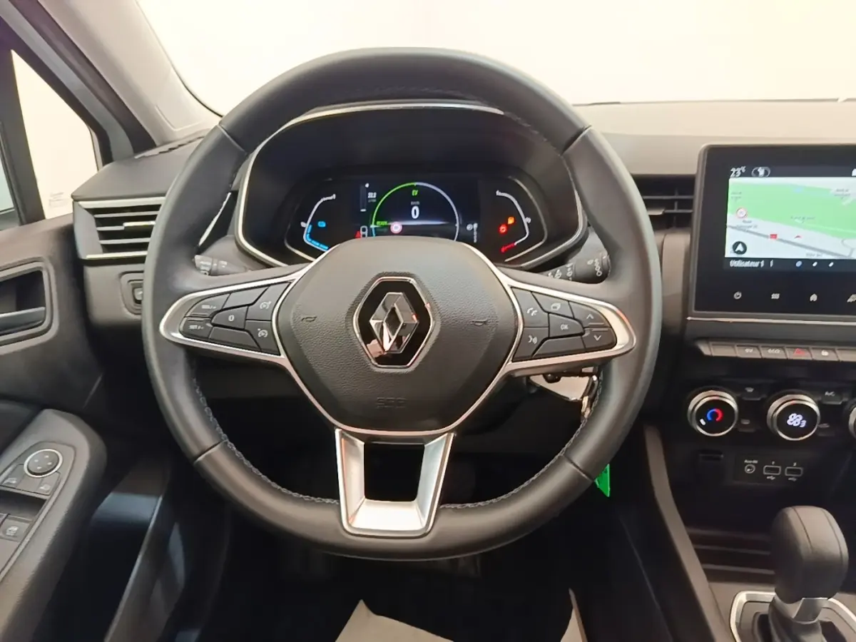 Vue intérieure centrée sur le volant cuir noir multifonctions et le tableau de bord avec écran tactile de la Renault Clio Business E-TECH.