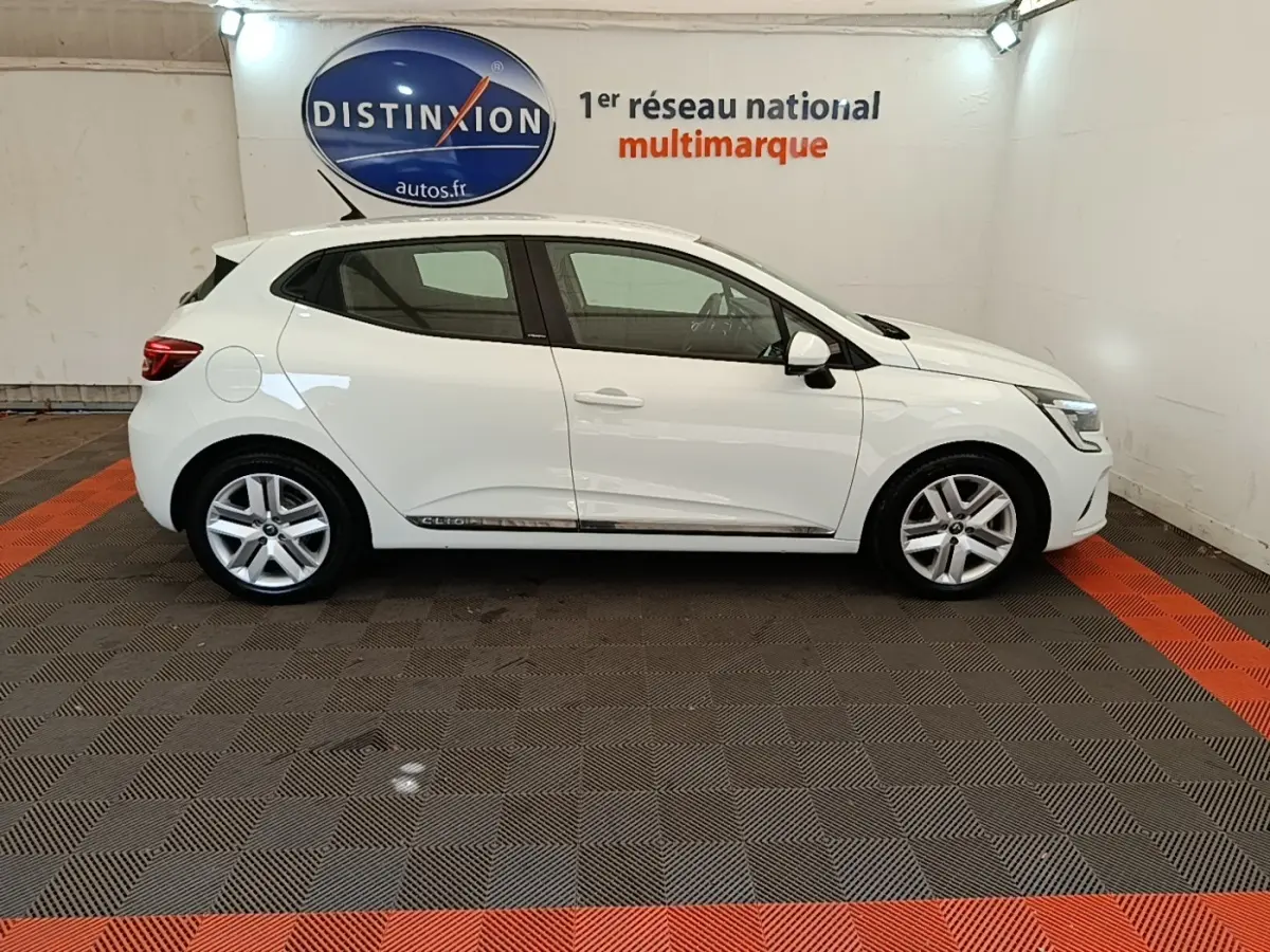 Profil droit d'une Renault Clio Business E-TECH 140 blanche de 2021, avec jantes alliage et logo Distinxion en arrière-plan.