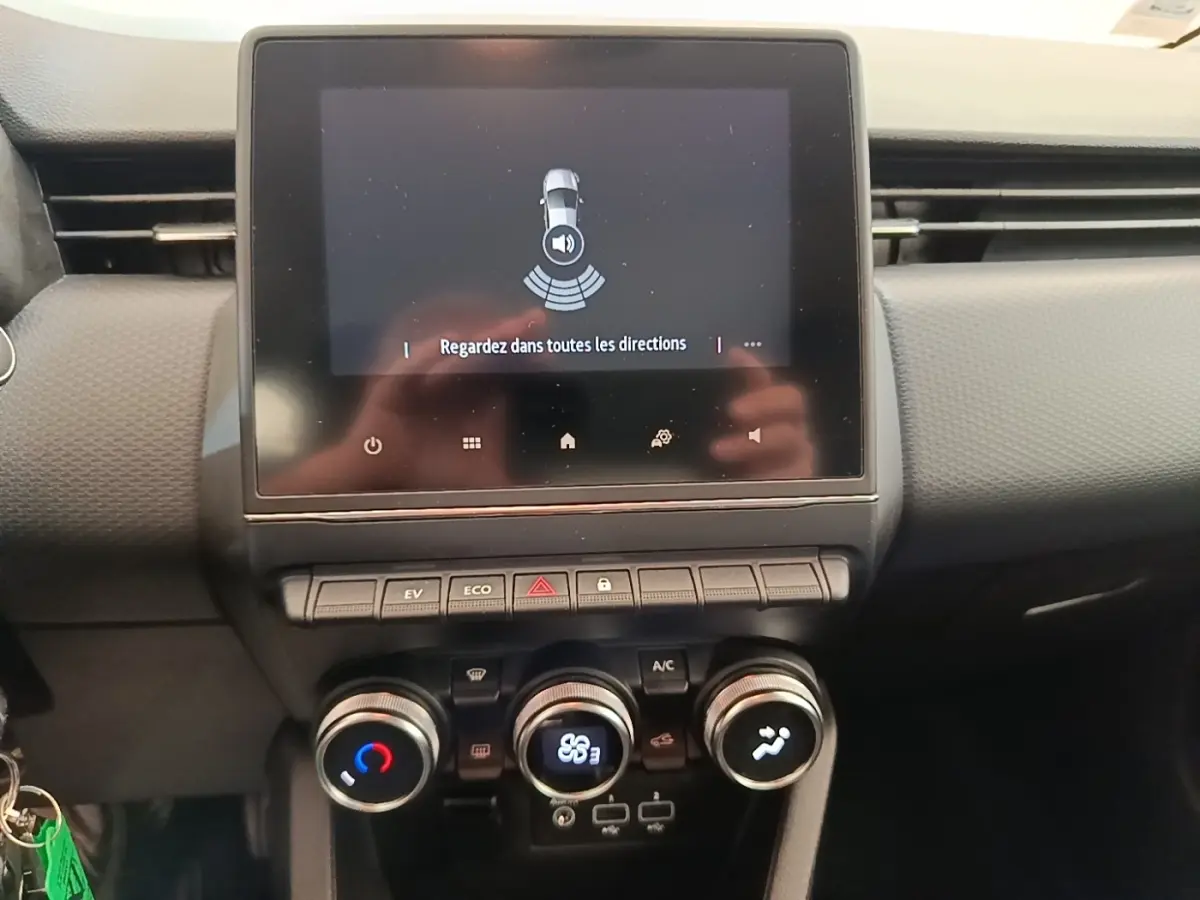 Vue rapprochée du tableau de bord de la Renault Clio Business E-TECH 140 avec écran tactile et commandes de climatisation.