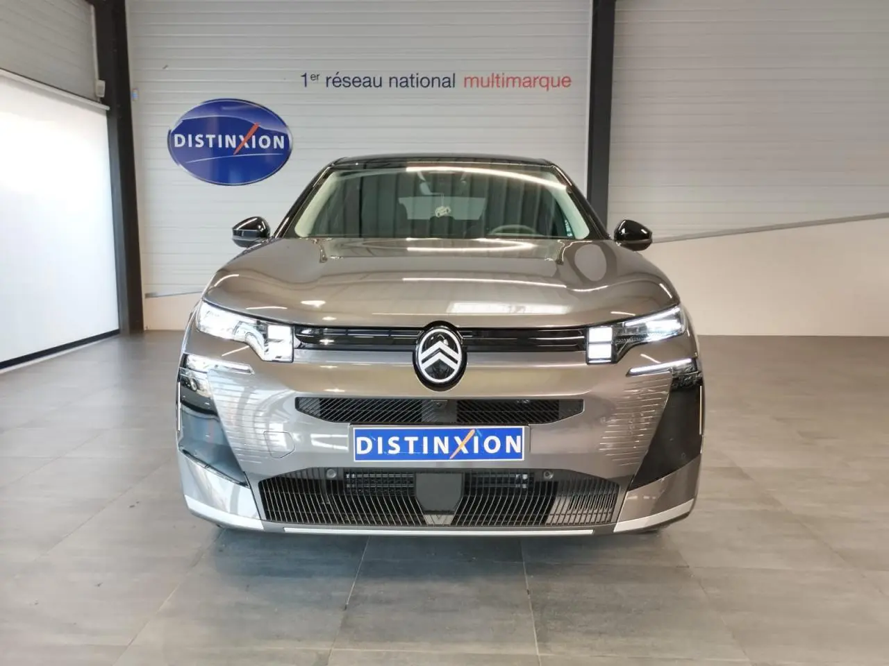 Vue frontale d'un Citroën C5 Aircross gris platine 2026 avec calandre noire brillante et feux LED distinctifs.