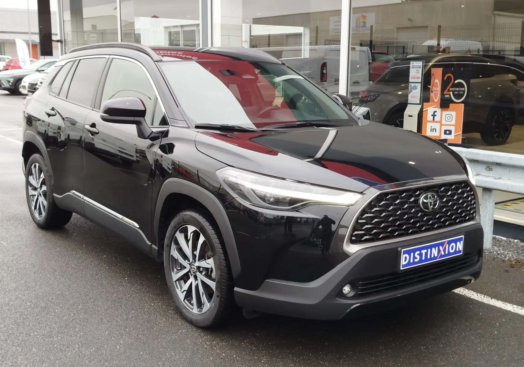 Toyota Corolla Cross Hybrid 140 Luxury Limited noir Attitude vue 3/4 avant droit, calandre et jantes distinctives visibles.