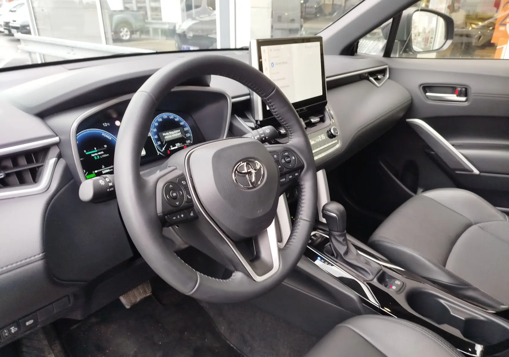 Vue intérieure côté conducteur de la Toyota Corolla Cross Hybrid 140 Luxury Limited 2025 avec tableau de bord numérique et écran tactile central.