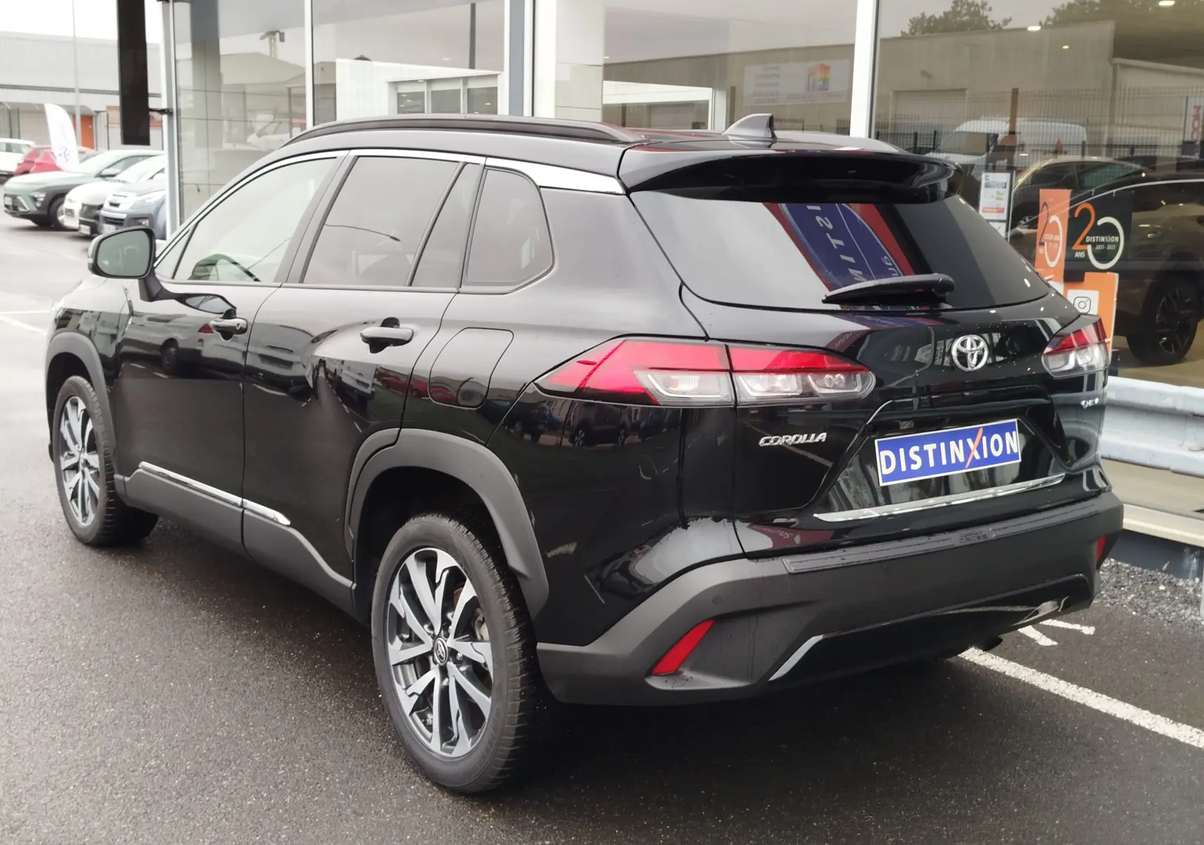 Vue 3/4 arrière droite d'un Toyota Corolla Cross Hybrid 140 Luxury Limited noir Attitude, avec jantes alliage et vitres teintées.