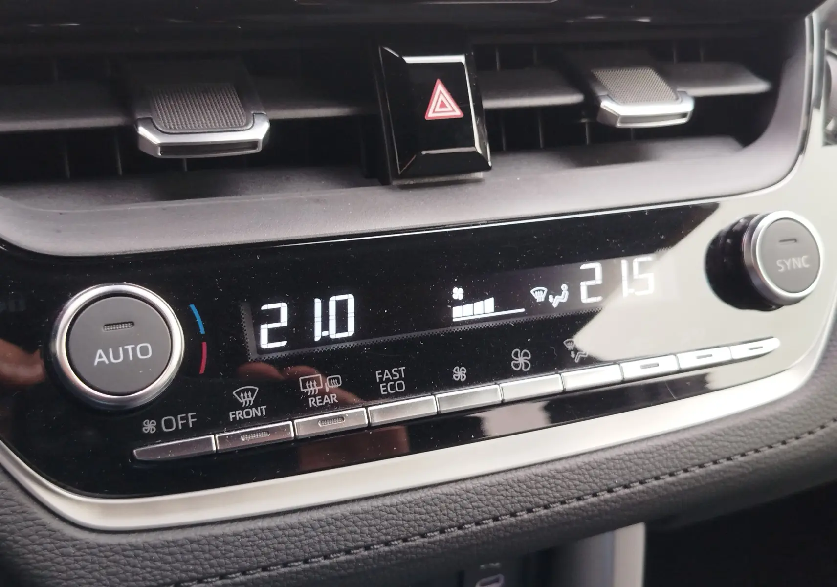Gros plan sur la console de climatisation digitale de la Toyota Corolla Cross Hybrid 140 Luxury Limited, affichant 21°C à gauche et 21,5°C à droite.