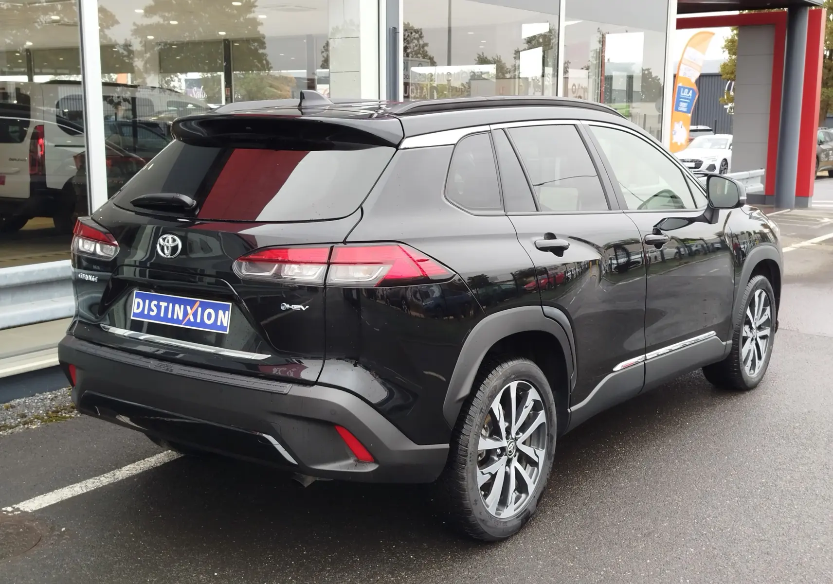 Toyota Corolla Cross Hybrid 140 Luxury Limited noir Attitude vue 3/4 arrière droit, jantes alliage bicolores et vitres teintées.