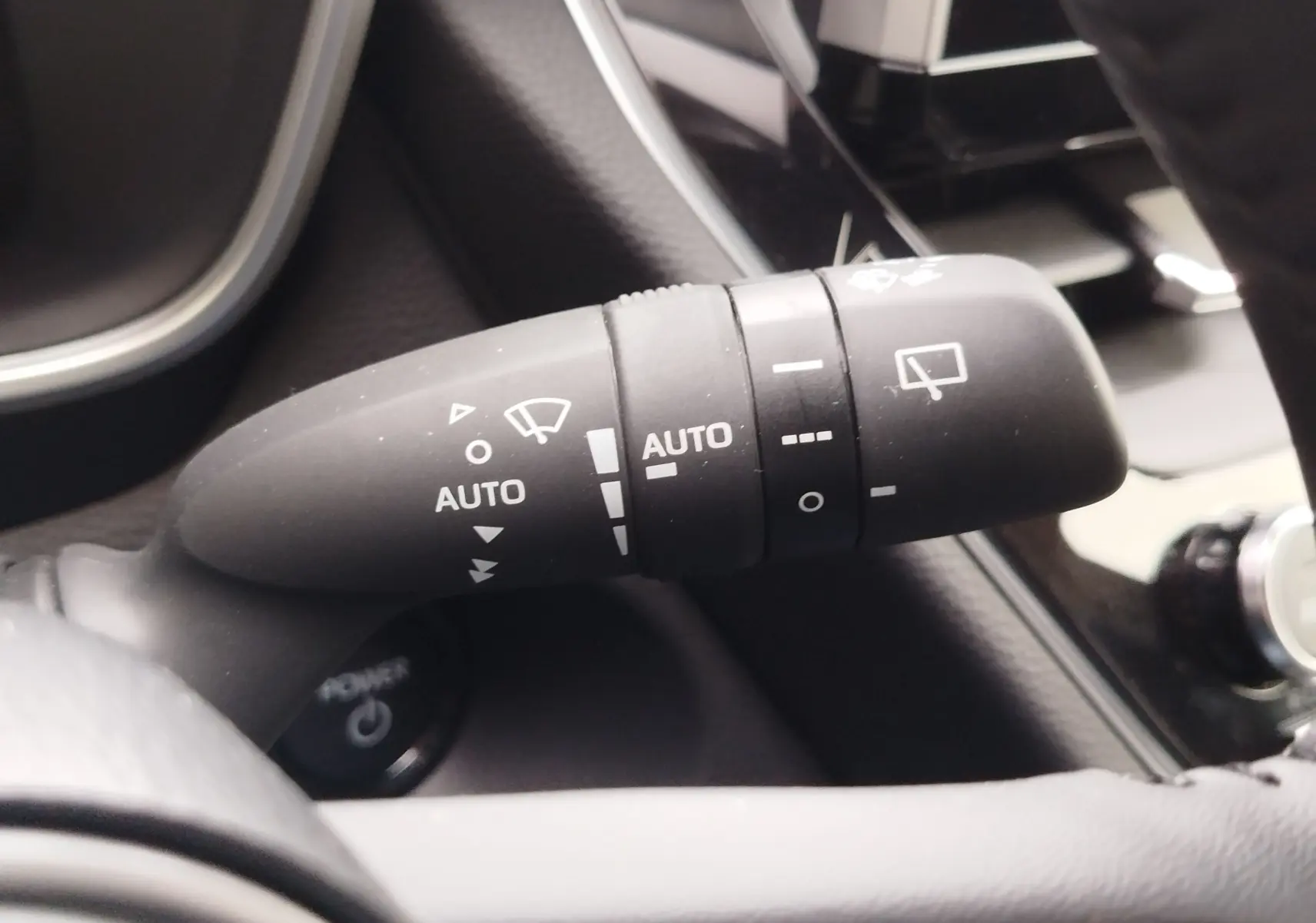 Gros plan sur la commande d’essuie-glace automatique du Toyota Corolla Cross Hybrid 140 Luxury Limited 2025, intérieur noir.