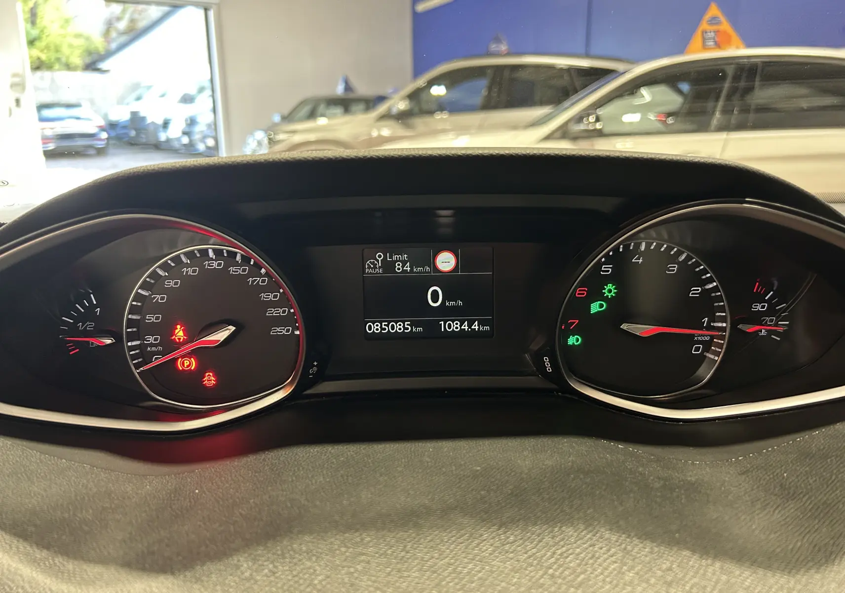 Tableau de bord de Peugeot 308 gris 2021 montrant compteurs, jauge carburant et écran digital avec 85 085 km affichés.