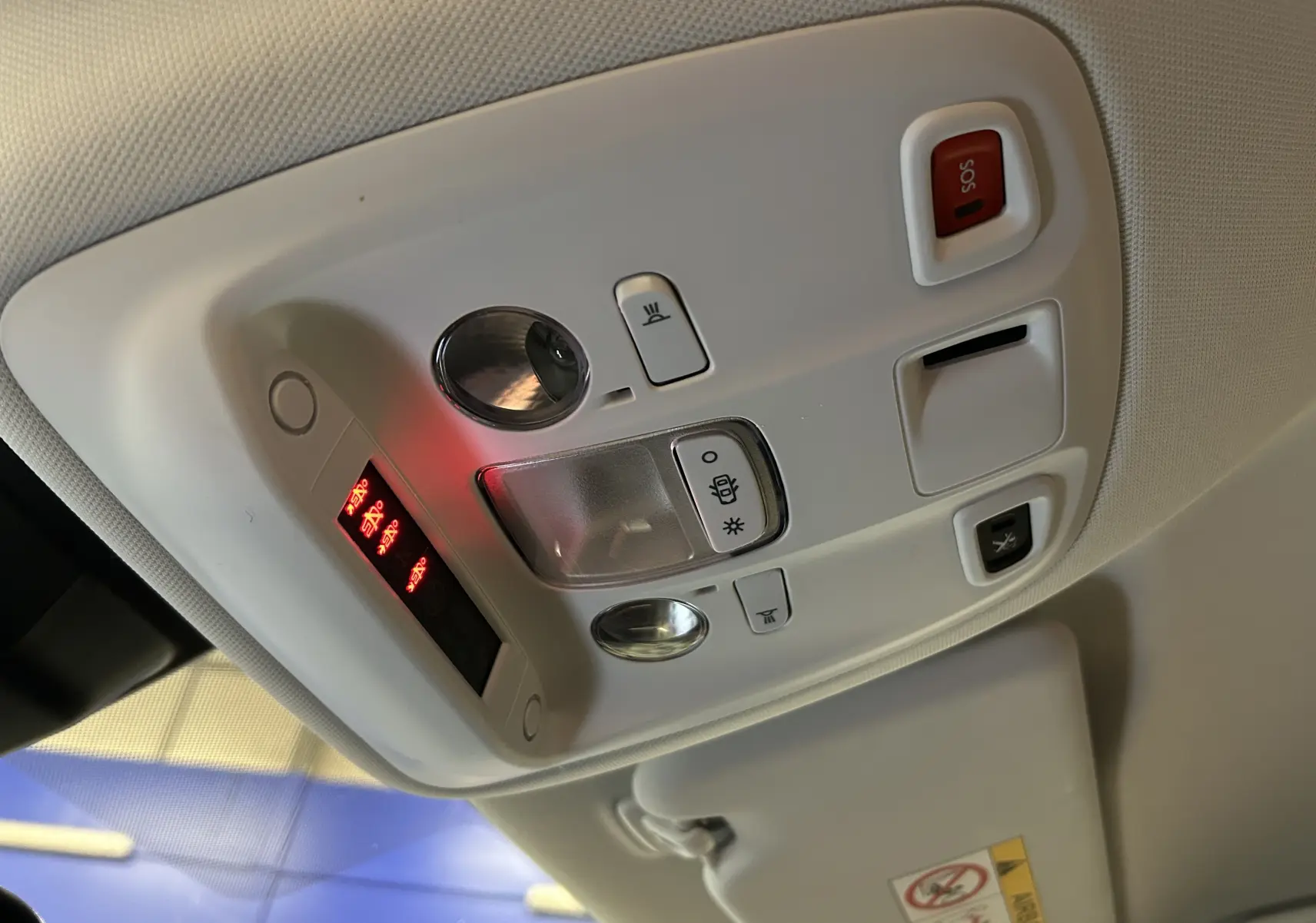 Vue en gros plan du plafonnier blanc avec commandes lumineuses et bouton SOS dans l’habitacle d’une Peugeot 308 gris 2021.