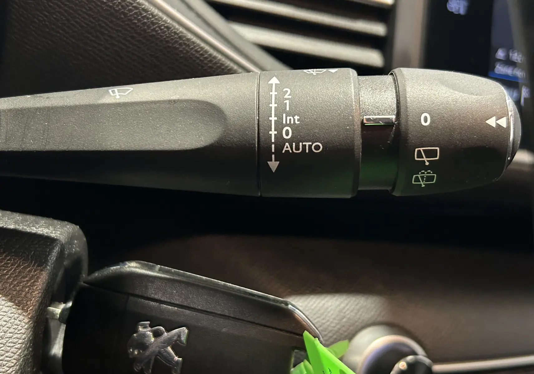 Gros plan sur la commande d’essuie-glace et la clé noire du Peugeot 308 gris, intérieur côté conducteur.