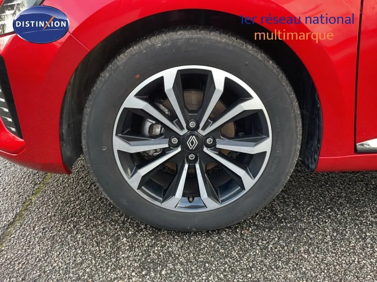 Gros plan sur la roue avant droite de la Renault Clio rouge Désir Métal 2025 avec jante alliage noire et argent.