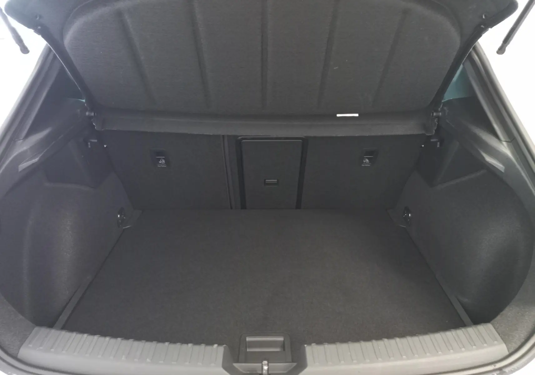 Coffre ouvert d'une CUPRA Leon Phase 2 1.5 eTSI 150 DSG7 V, intérieur spacieux et revêtement gris foncé.