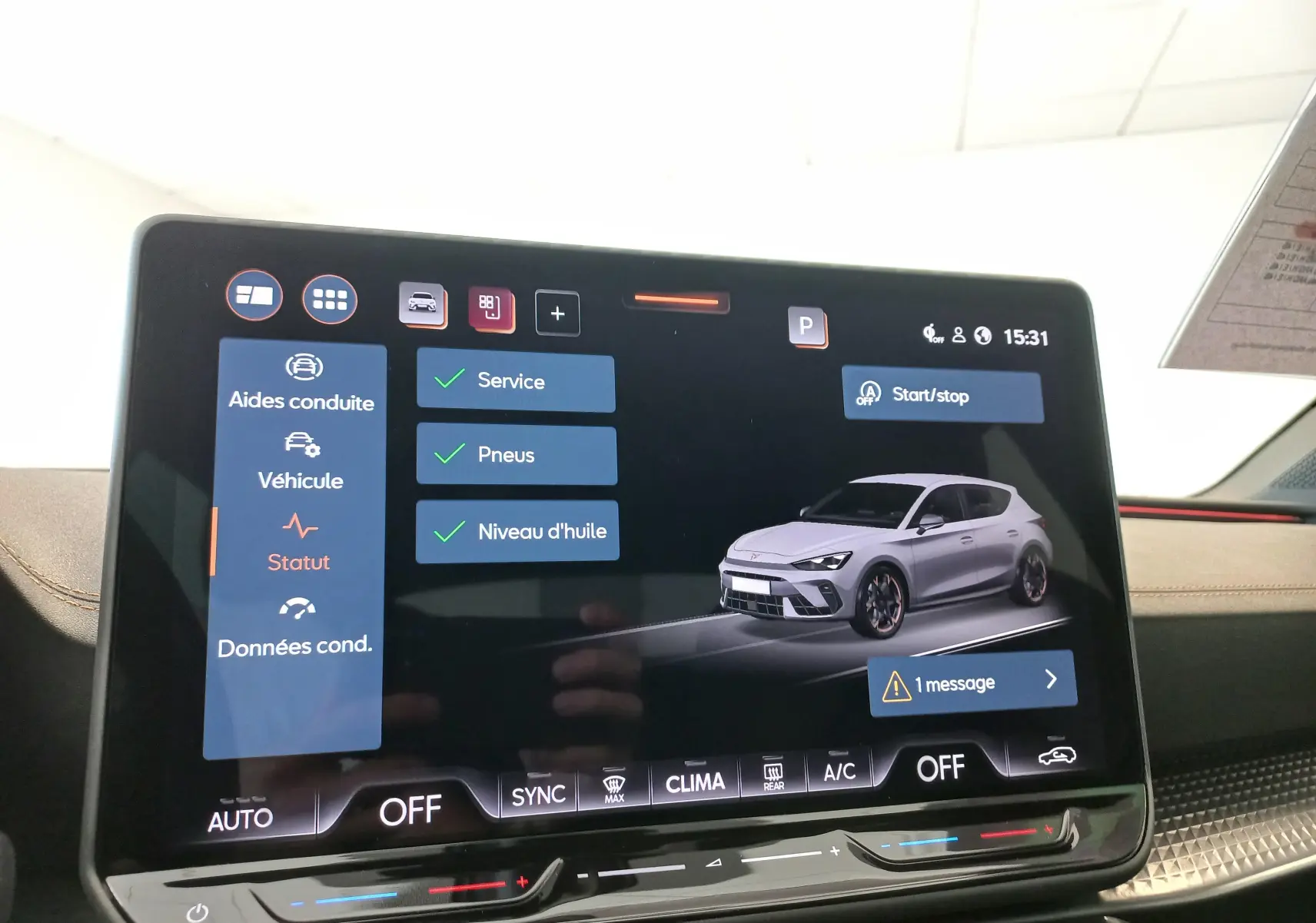 Écran tactile intérieur affichant une CUPRA Leon blanc Nevada en 3/4 avant avec interface de contrôle et menus visibles.