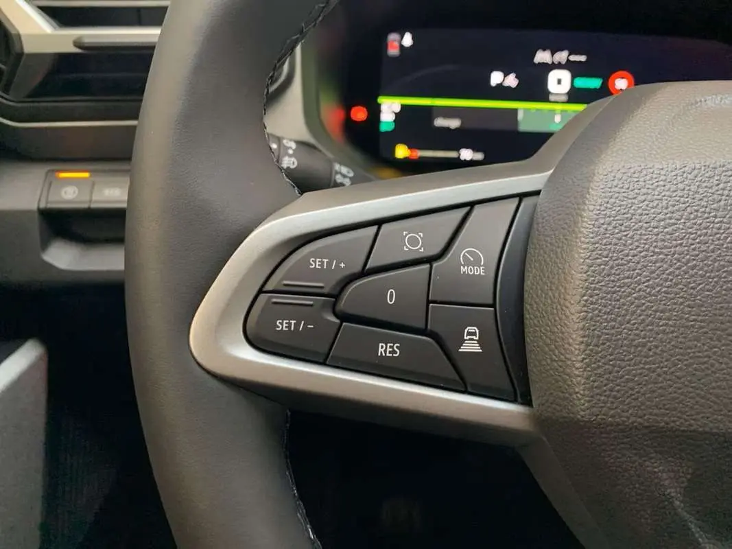 Gros plan sur les commandes au volant côté gauche du Dacia Bigster Hybrid 155 Journey Plus, volant cuir noir.