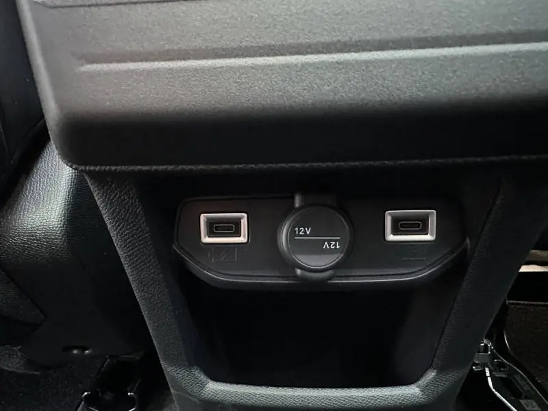 Gros plan sur la prise 12V et deux ports USB situés à l'arrière de la console centrale noire du Citroën C5 Aircross.