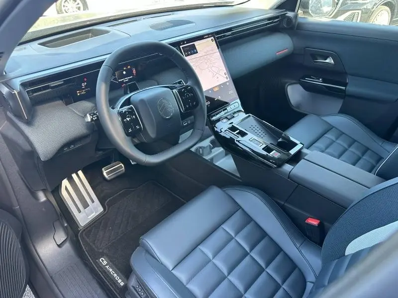 Vue intérieure côté conducteur du Citroën C5 Aircross 2026, avec sièges bleus, volant multifonction et écran tactile vertical.