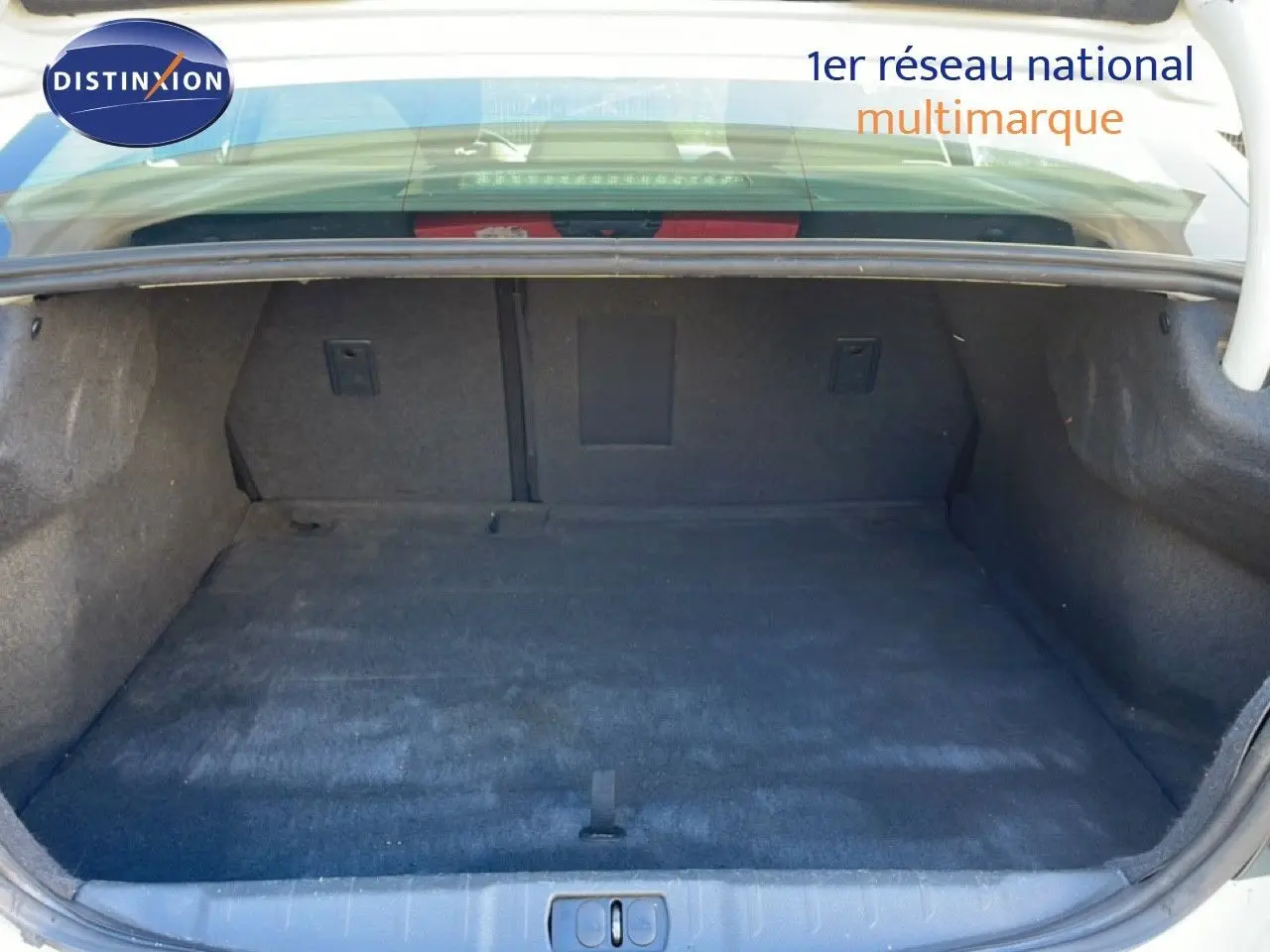 Coffre ouvert de la Peugeot 508 blanche de 2012, vue intérieure montrant un espace de chargement propre et spacieux.