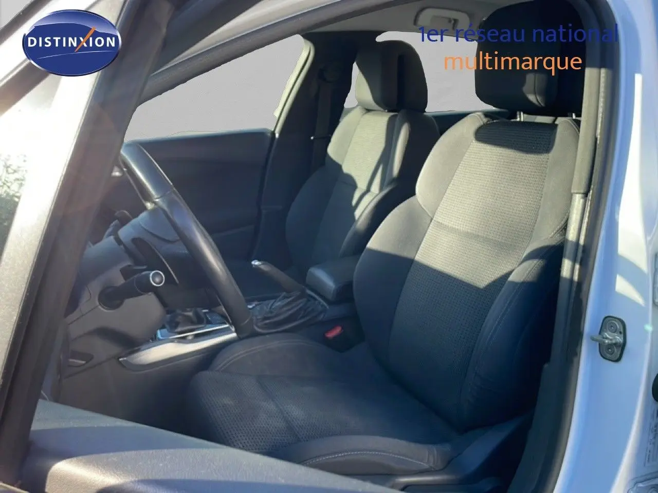 Intérieur de la Peugeot 508 blanc, vue côté gauche montrant les sièges avant en tissu noir et le volant.