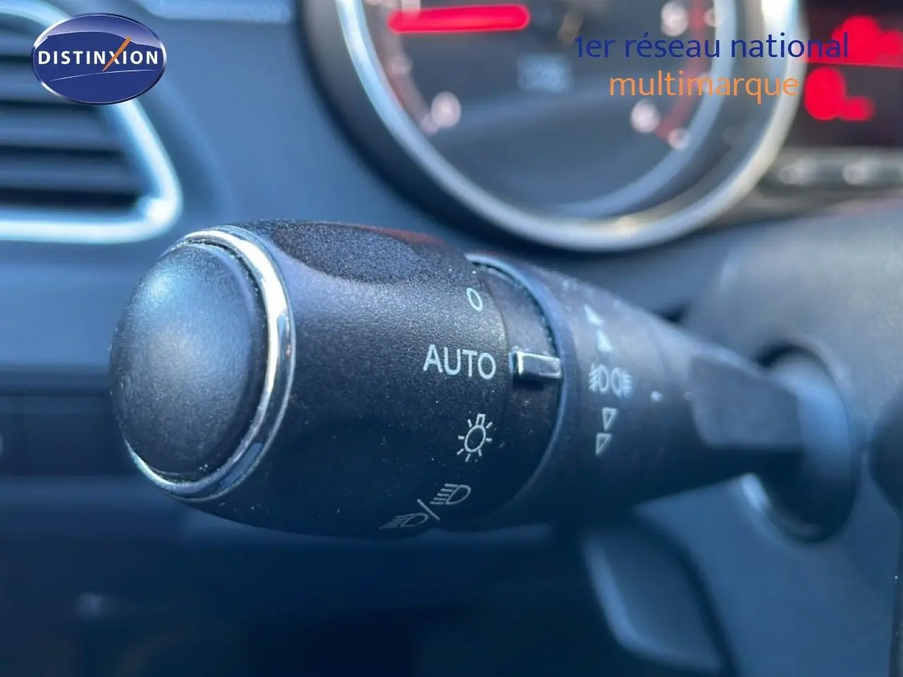 Gros plan sur la commande des phares automatique dans l'habitacle d'une Peugeot 508 blanche de 2012.