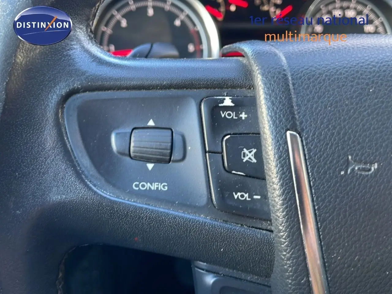 Détail du volant avec commandes de volume et configuration sur Peugeot 508 blanc, tableau de bord en arrière-plan.