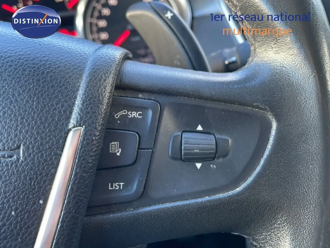 Gros plan sur les commandes au volant noir d'une Peugeot 508 blanche, version 1.6 E-HDI 115CH de 2012.