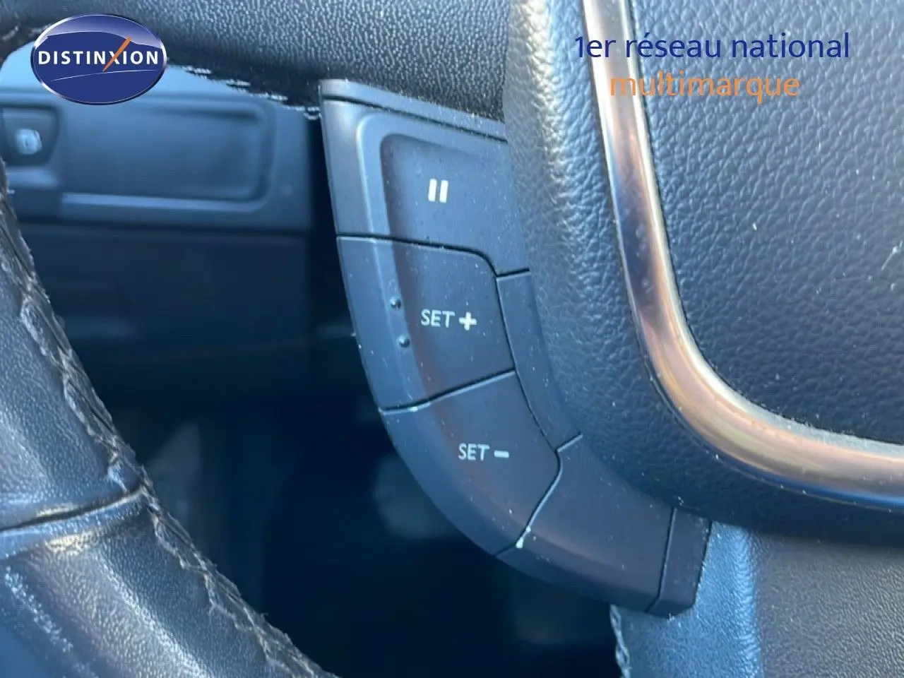 Détail du volant en cuir noir avec commandes de régulateur de vitesse sur une Peugeot 508 blanche de 2012