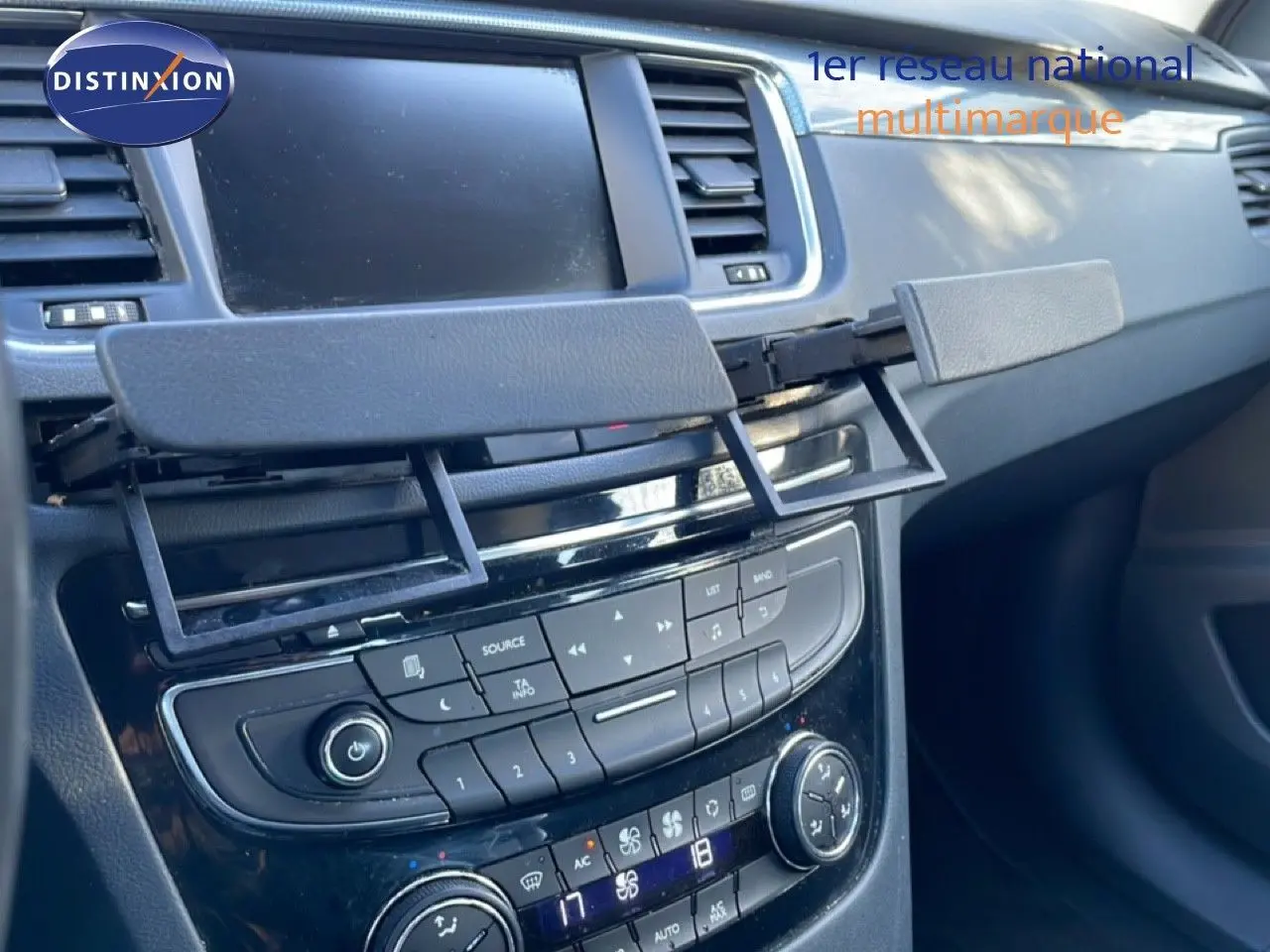 Détail de la console centrale noire avec écran et commandes climatisation d'une Peugeot 508 blanche de 2012
