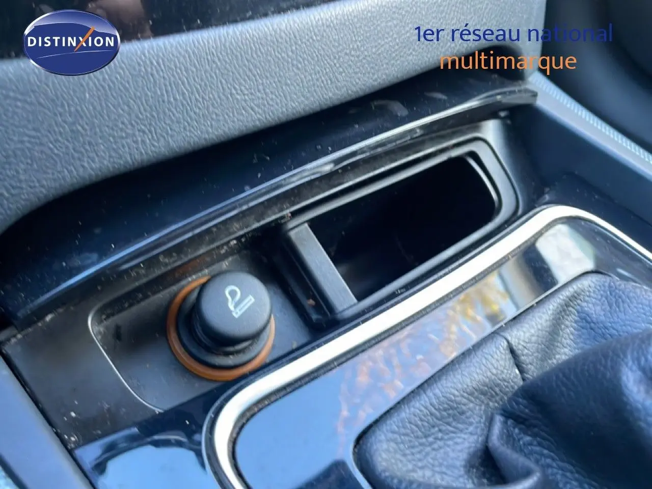 Gros plan sur la console centrale noire du Peugeot 508 blanc, mettant en valeur l'allume-cigare et le levier de vitesses cuir.