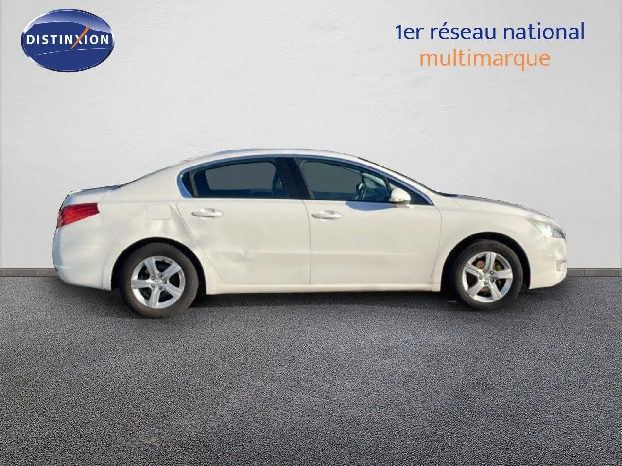 Profil côté gauche d'une Peugeot 508 blanche de 2012 avec une bosse visible sur la porte arrière.
