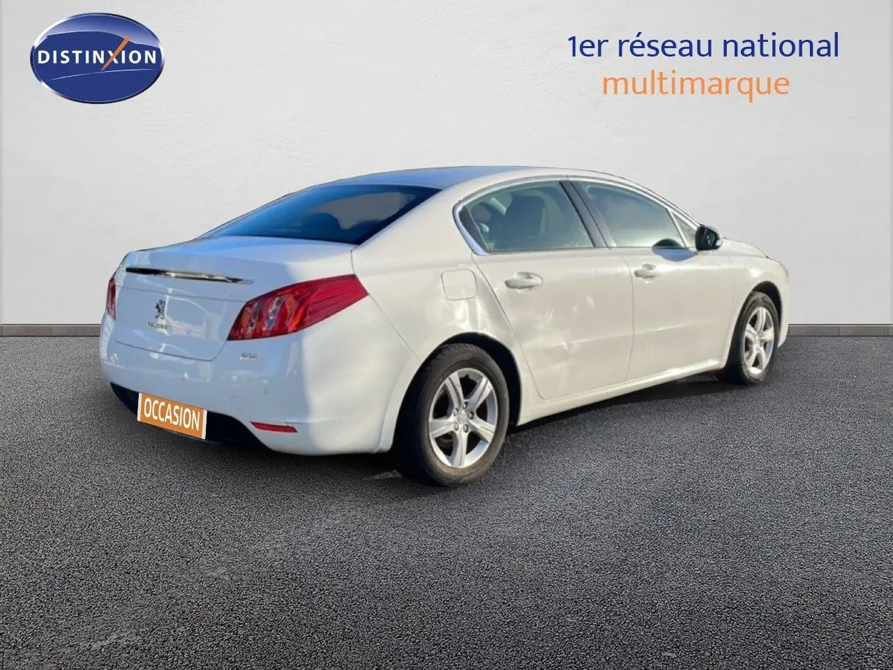 Peugeot 508 blanche vue de trois quarts arrière côté droit, avec jantes alliage et carrosserie lisse.