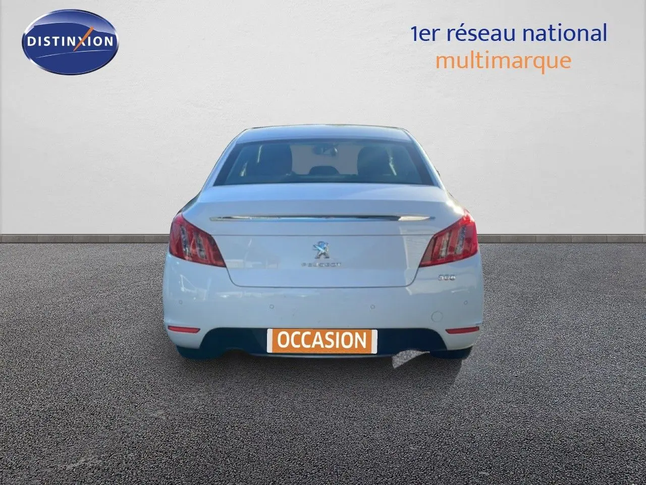 Vue arrière d'une Peugeot 508 blanche de 2012 avec plaque "OCCASION" sur un sol gris uniforme.