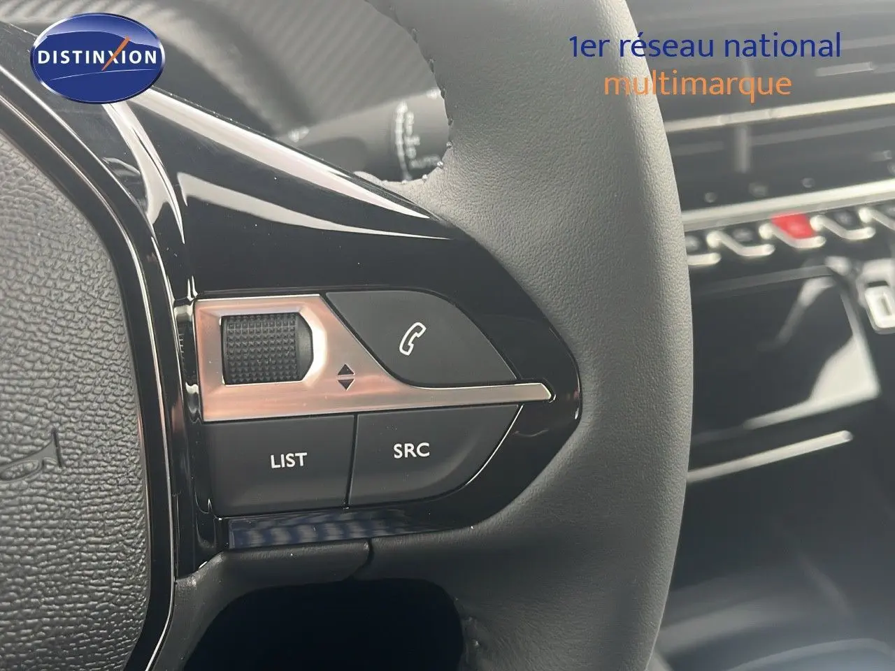 Gros plan sur les commandes gauche du volant noir du Peugeot 2008 blanc Okenite Metal, avec boutons de téléphone et liste.