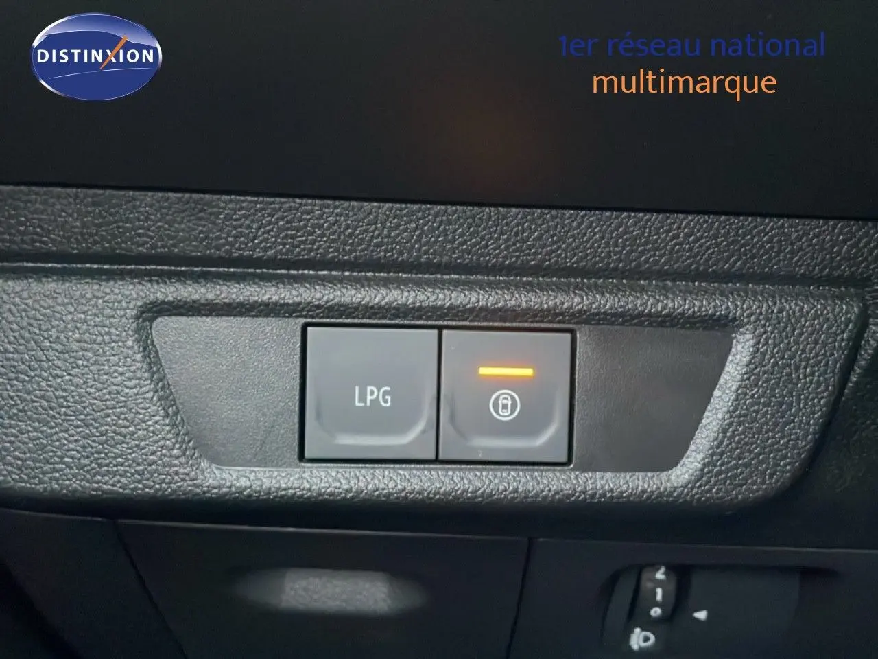 Gros plan sur les boutons de commande LPG et verrouillage intérieur du tableau de bord d'une Dacia Jogger vert cèdre métal.