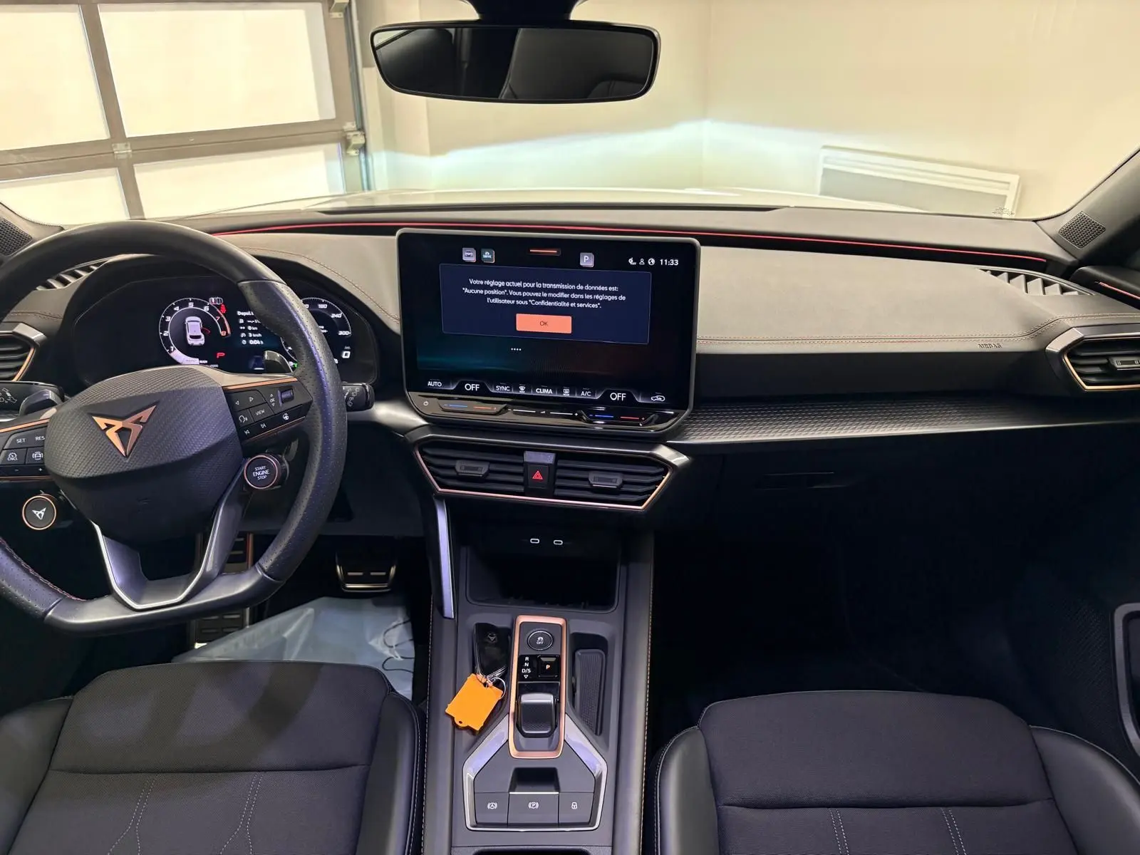 Vue intérieure du poste de conduite de la CUPRA Leon 2025, tableau de bord moderne avec écran tactile central et volant multifonction.