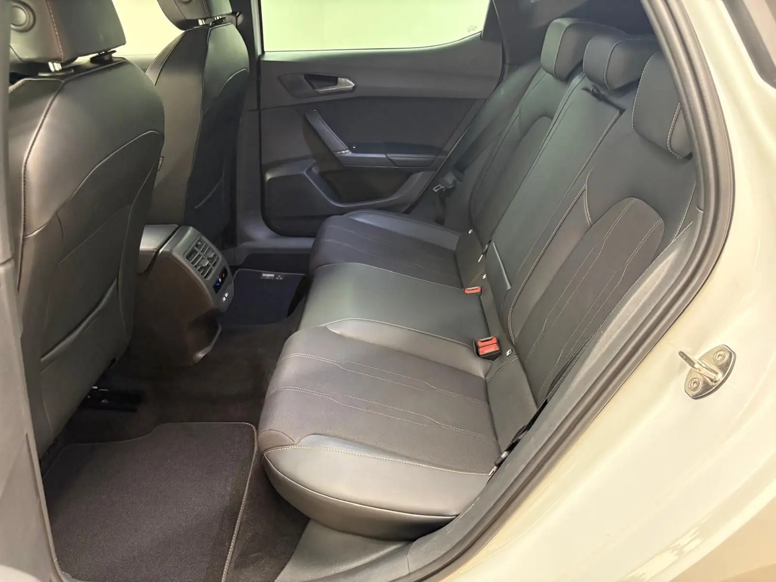 Vue côté droit arrière sur l'intérieur noir cuir de la CUPRA Leon 2025 avec porte ouverte et détails des sièges arrière.