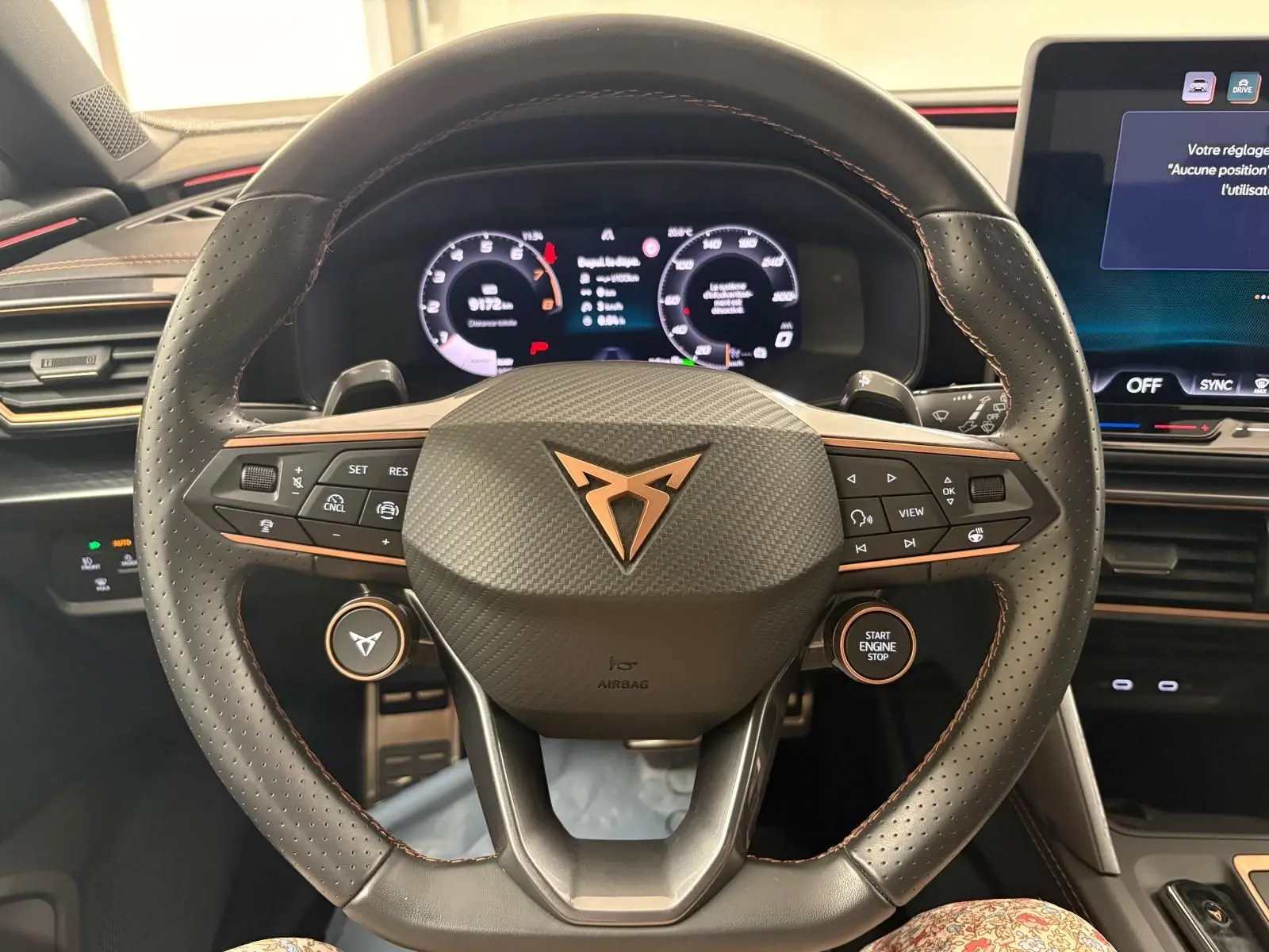 Vue rapprochée du volant noir perforé avec logo CUPRA cuivré et commandes intégrées du CUPRA Leon 2025.