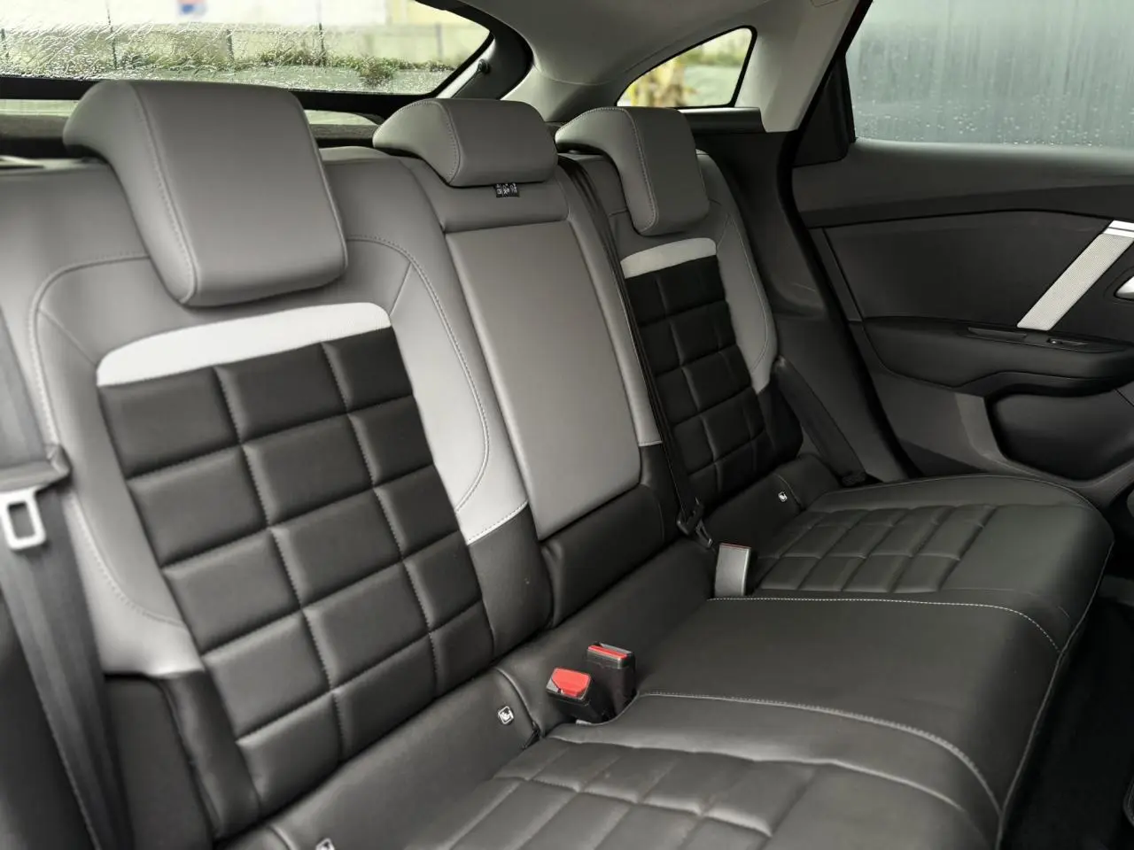 Vue intérieure de la banquette arrière bicolore noire et grise de la Citroën C4 Hybrid 2025, côté droit.