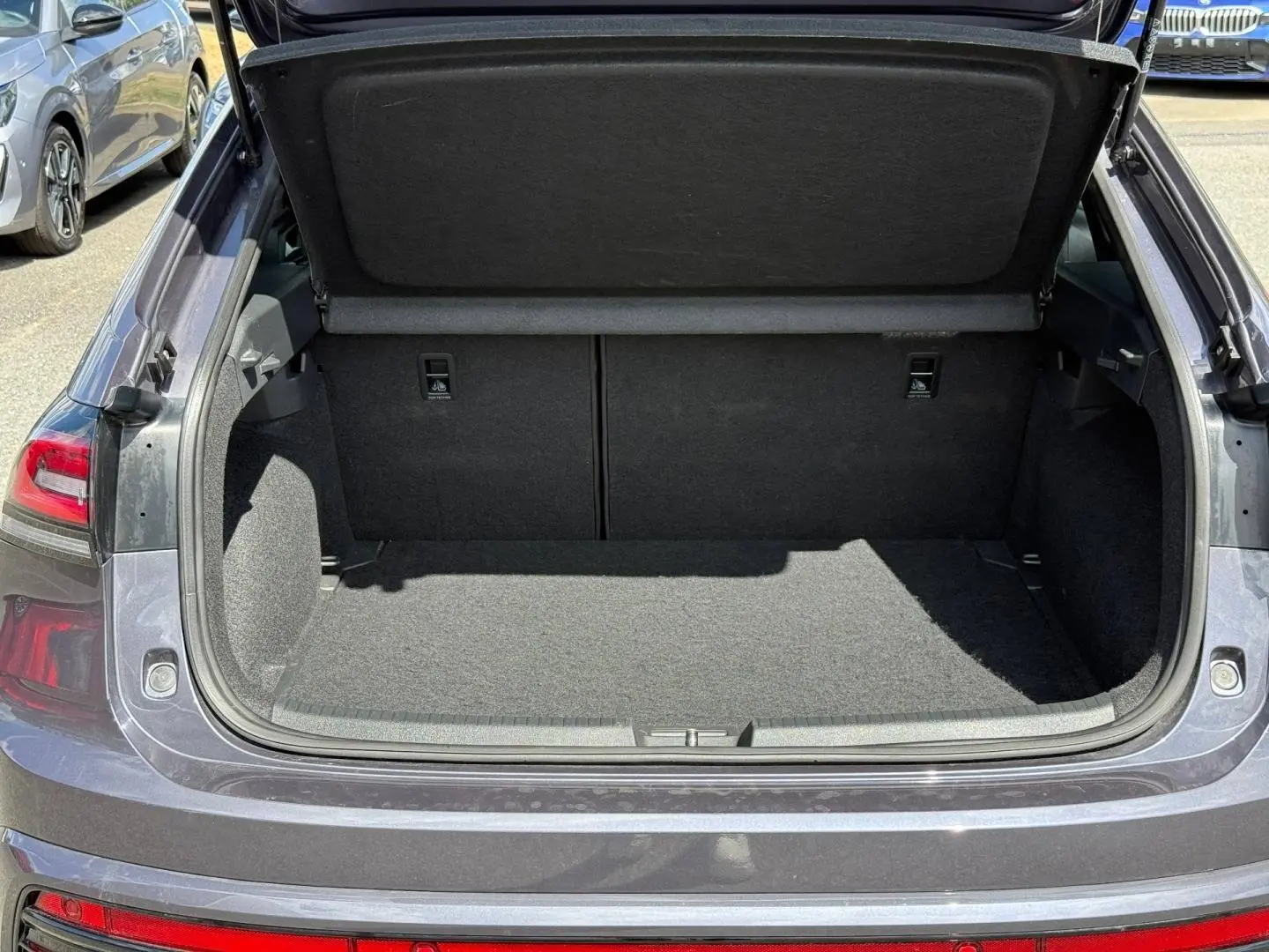Coffre ouvert vu de l'arrière d'un Volkswagen Taigo gris Ascot 2025, montrant l'espace de chargement vide.