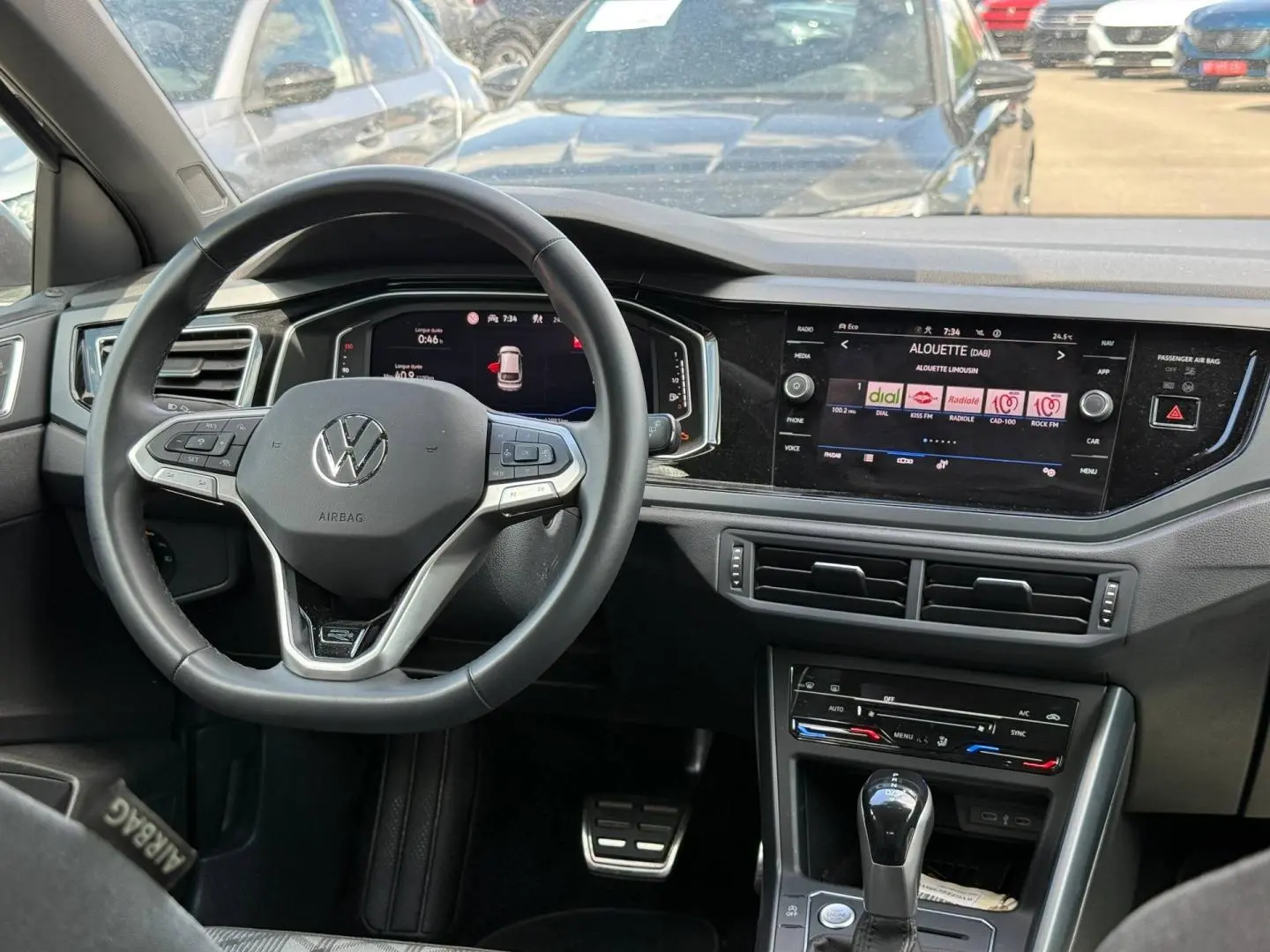 Vue intérieure du tableau de bord du Volkswagen Taigo gris 2025, volant cuir multifonction et écran tactile central.