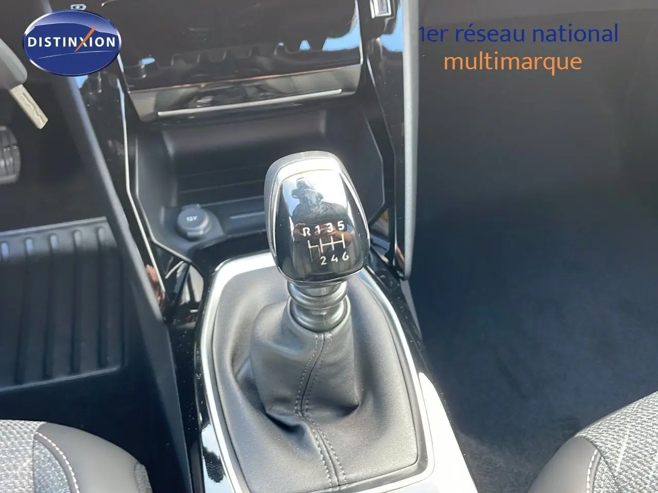 Le levier de vitesses manuel noir de la Peugeot 2008 gris Artense, vu en gros plan depuis l'habitacle.