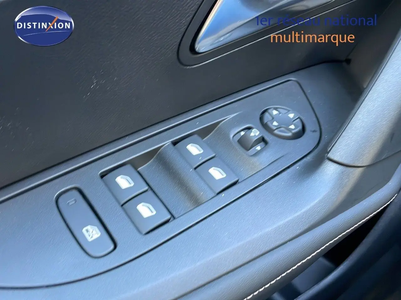 Gros plan sur les commandes des vitres électriques et rétroviseurs côté conducteur du Peugeot 2008 gris Artense 2025.