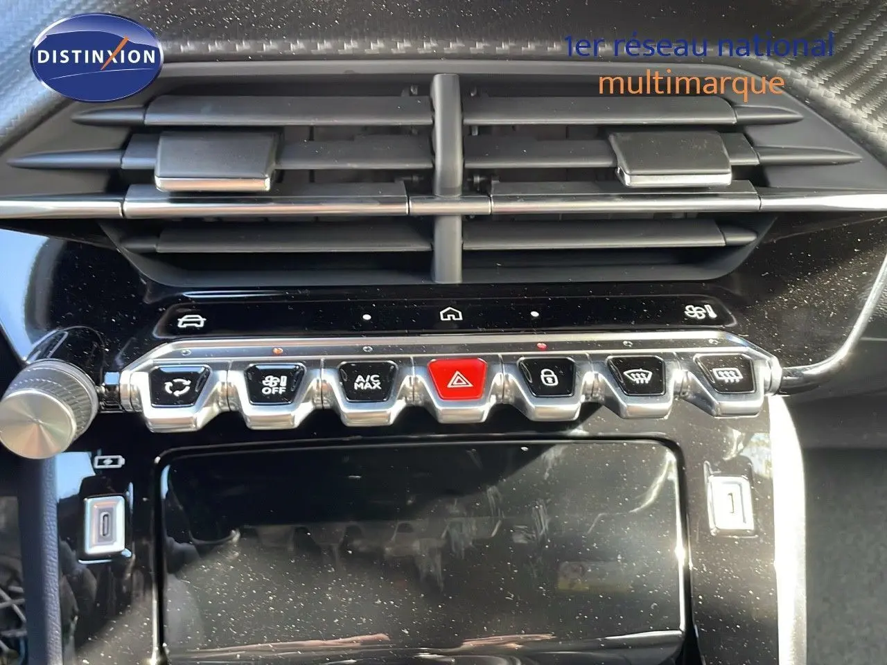 Gros plan sur la console centrale du Peugeot 2008 gris Artense, mettant en valeur les commandes climatisation et boutons fonctionnels.