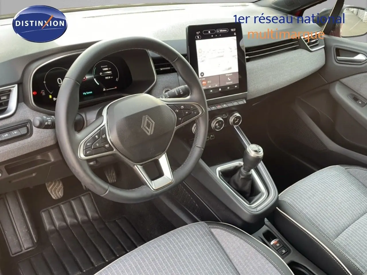 Vue intérieure de la Renault Clio 2025, montrant le volant, la console centrale avec boîte manuelle et l’écran tactile.