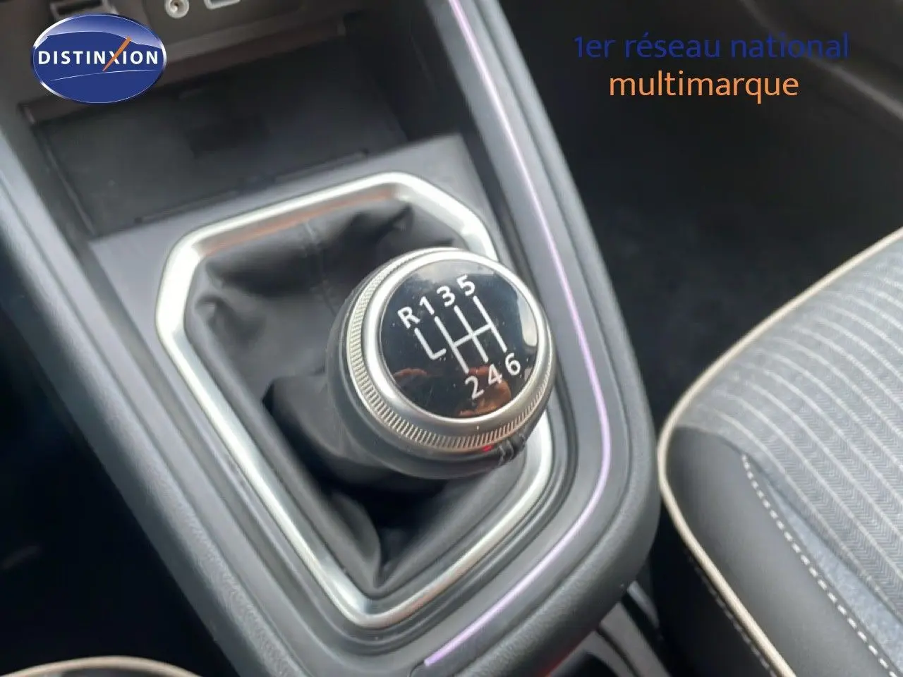 Gros plan sur le levier de vitesses manuel de la Renault Clio 2025, intérieur avec sellerie grise à surpiqûres blanches.