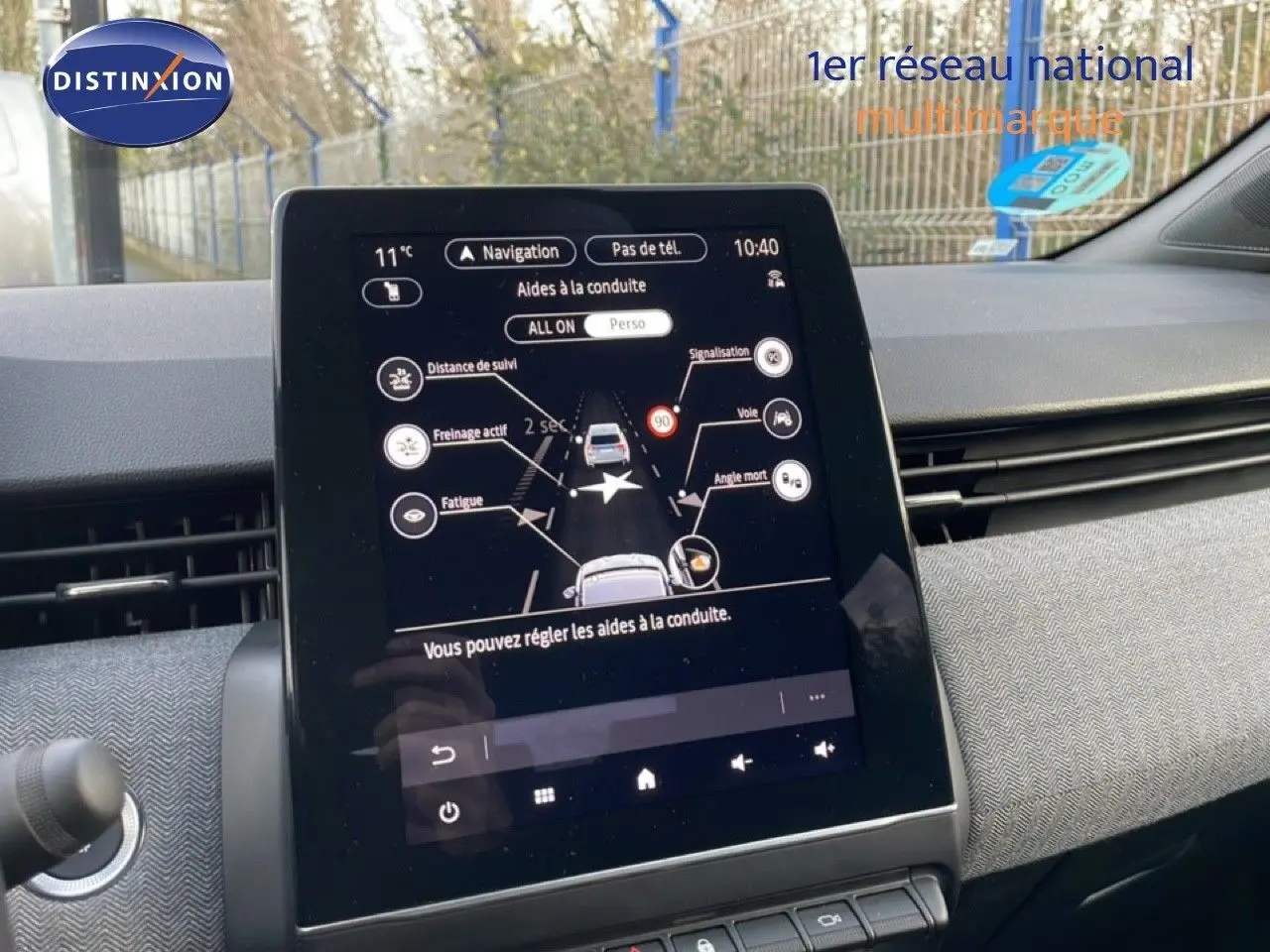 Tablette tactile centrale affichant les aides à la conduite dans une Renault Clio rouge désir métal, vue intérieure avant.