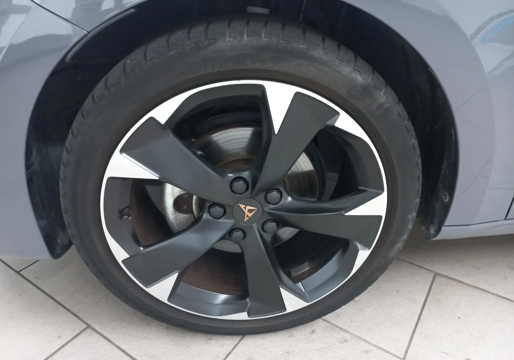 Gros plan sur la jante noire et argentée avec logo CUPRA d'une roue avant droite d'une CUPRA Leon gris Graphene.
