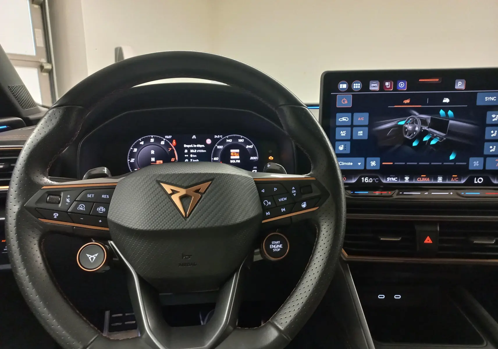 Vue intérieure centrée sur le volant noir perforé avec logo CUPRA et tableau de bord numérique lumineux.