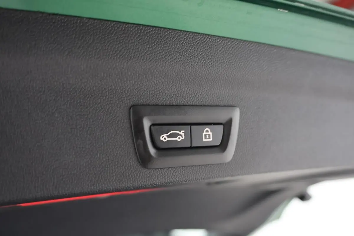 Boutons d'ouverture et de verrouillage du coffre sur la partie intérieure du hayon d'un MINI Countryman vert métallisé.